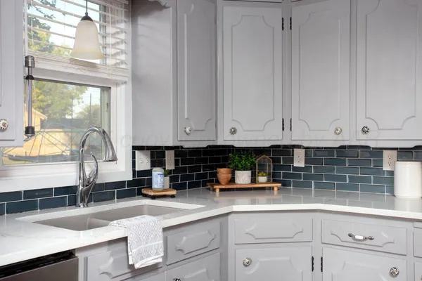 a kitchen with granite countertop a sink white cabinets and a window