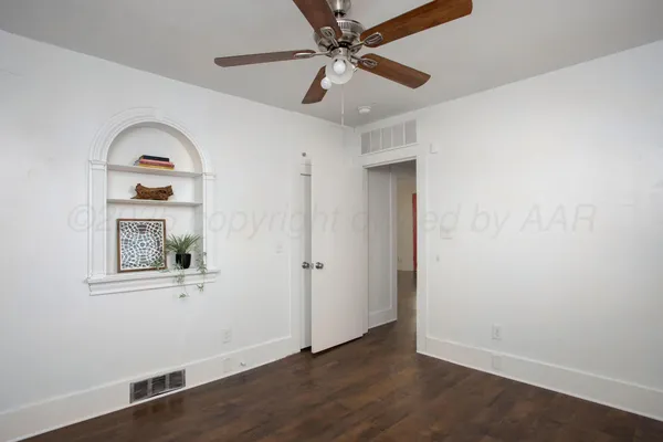 an empty room with a window and wooden floor
