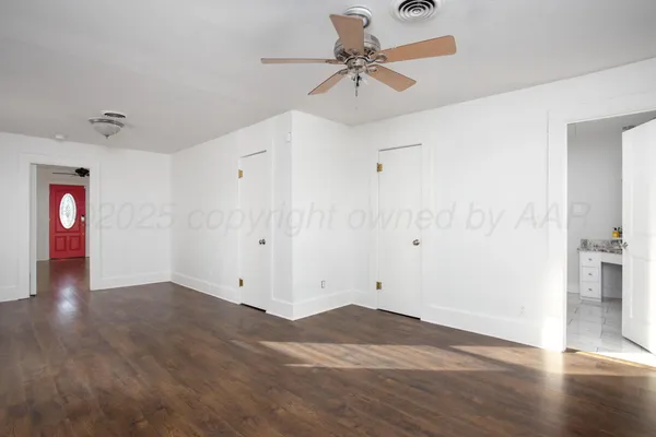 a view of an empty room with wooden floor