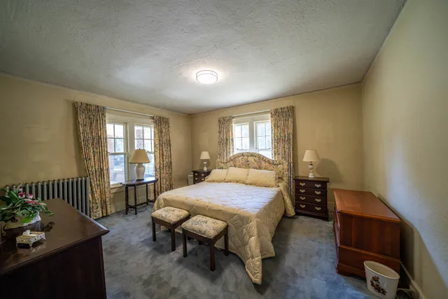 a bathroom with a double vanity sink a mirror and a bathtub next to a window