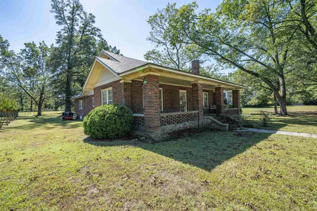 a view of a house with backyard and trees
