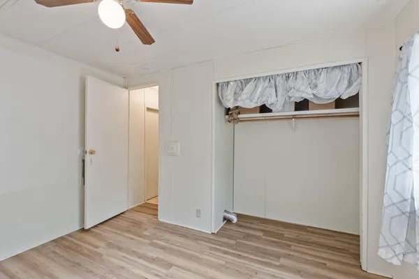 a view of empty room with wooden floor