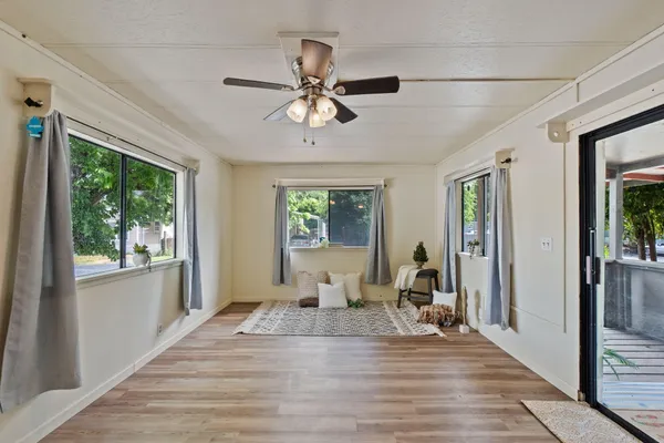 a view of a livingroom with wooden floor and a ceiling fan