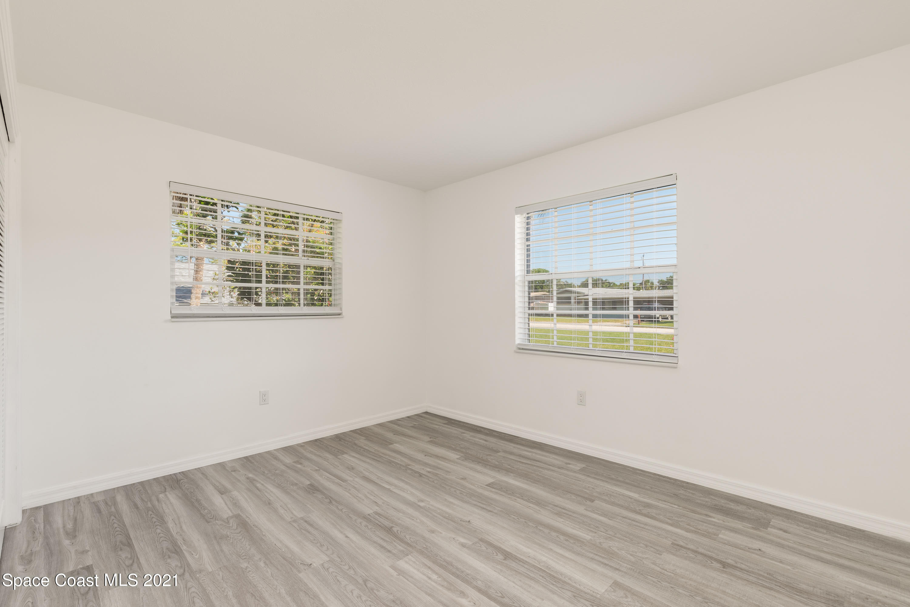 640 Java Road Cocoa Beach, FL 32931 - Photo 10 of 18 a view of an empty room with wooden floor and a window
