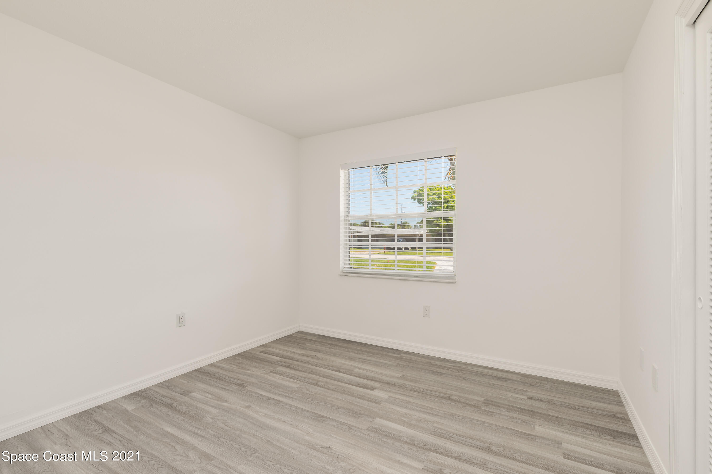 640 Java Road Cocoa Beach, FL 32931 - Photo 11 of 18 an empty room with wooden floor and windows