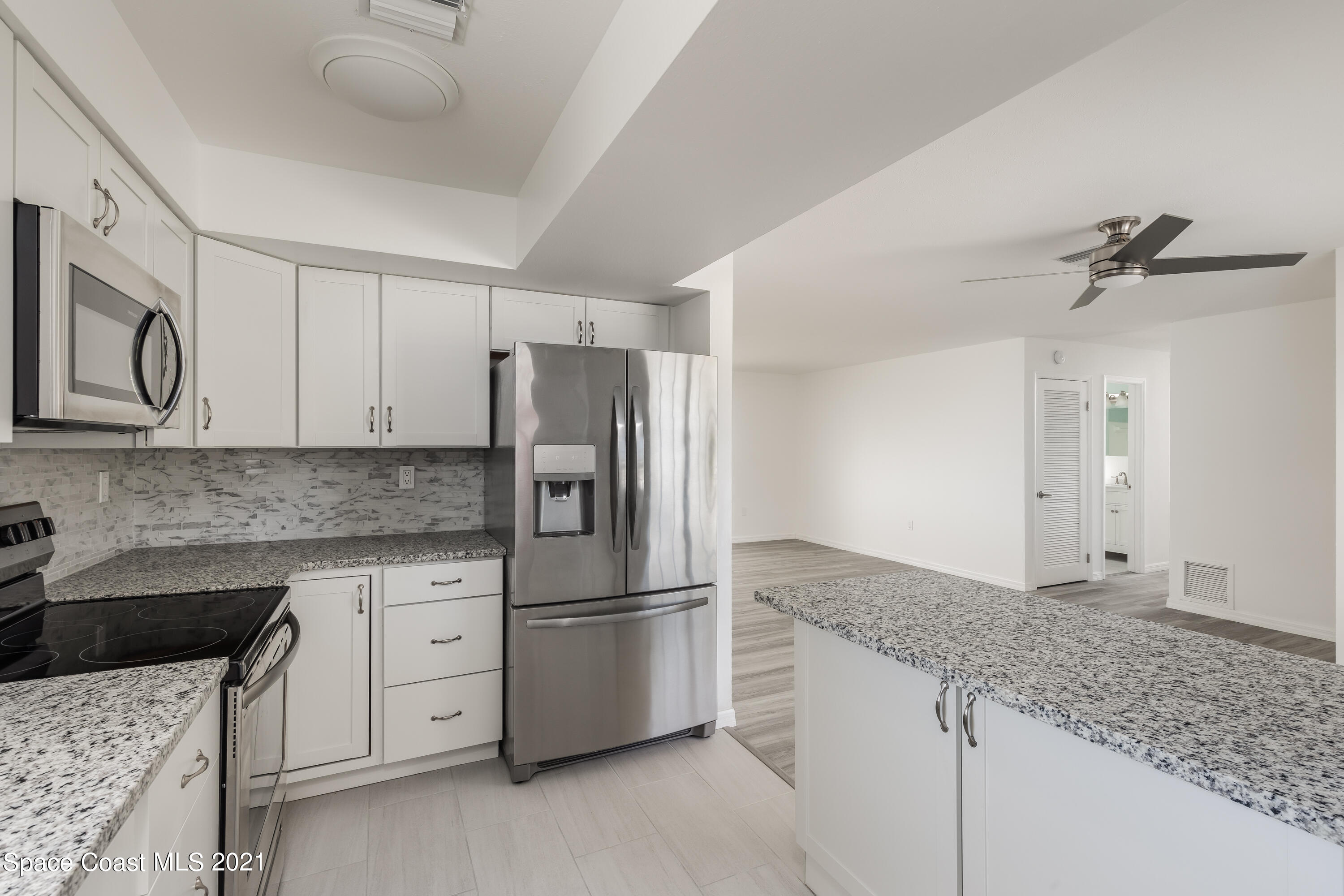 640 Java Road Cocoa Beach, FL 32931 - Photo 3 of 18 a kitchen with granite countertop a sink stove and refrigerator