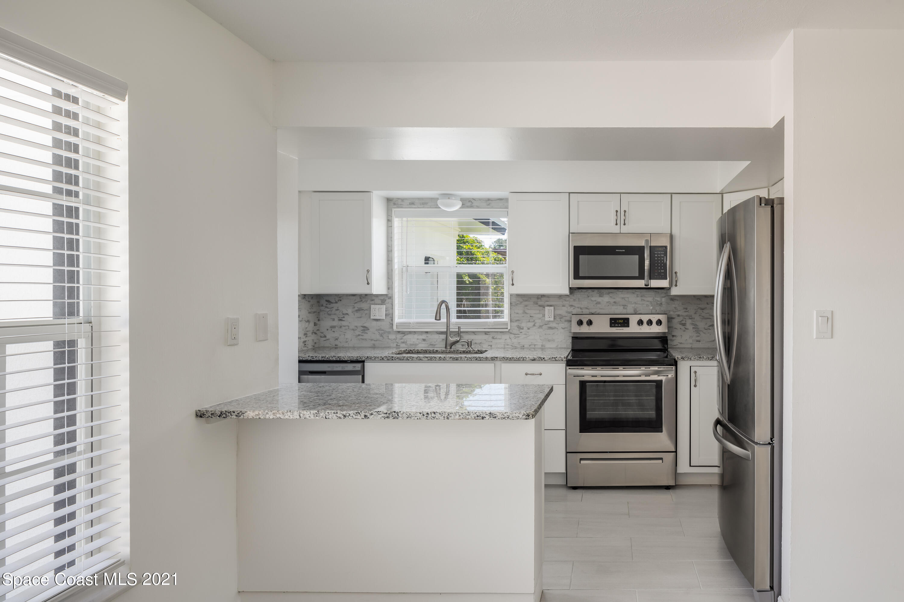 640 Java Road Cocoa Beach, FL 32931 - Photo 4 of 18 a kitchen with stainless steel appliances granite countertop a stove microwave and sink