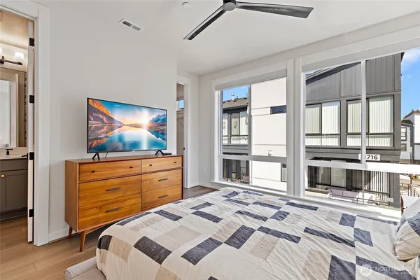 a bedroom with a bed a table and windows