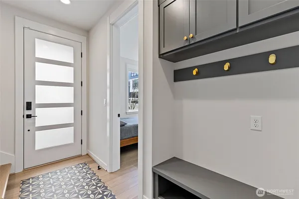 a kitchen with stainless steel appliances kitchen island granite countertop a refrigerator a stove a sink and white cabinets with wooden floor