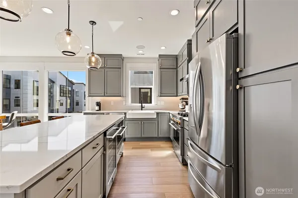 a dining room with stainless steel appliances kitchen island granite countertop a dining table chairs and a white refrigerator