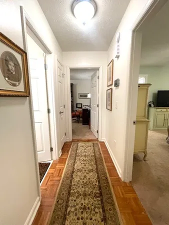 a view of a hallway with wooden floor and staircase