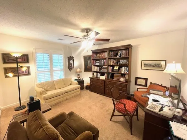 a living room with furniture a rug and a bookshelf