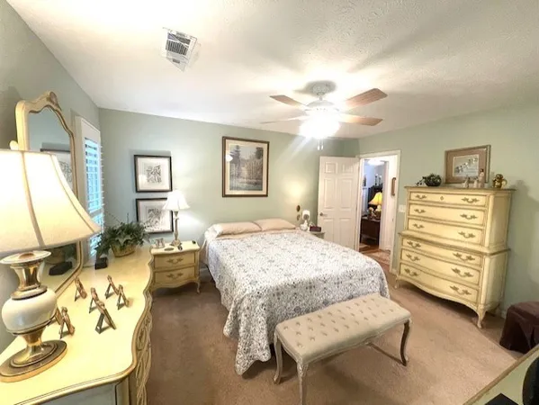 a spacious bedroom with a bed and wooden floor