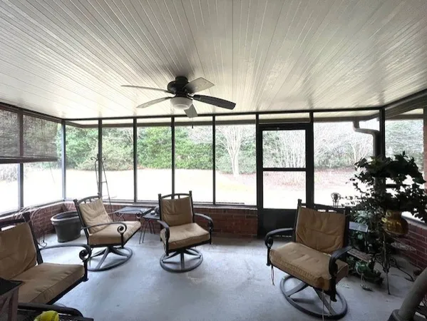 a living room with furniture and floor to ceiling windows