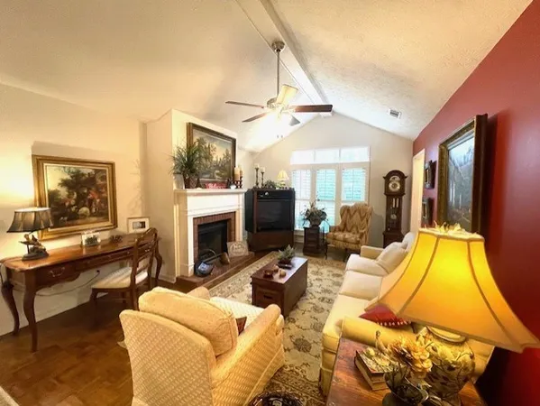 a living room with furniture a flat screen tv and a fireplace