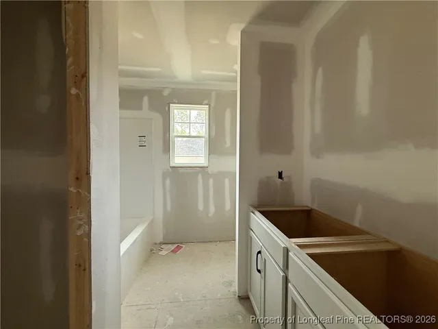 a utility room with a sink a refrigerator and window