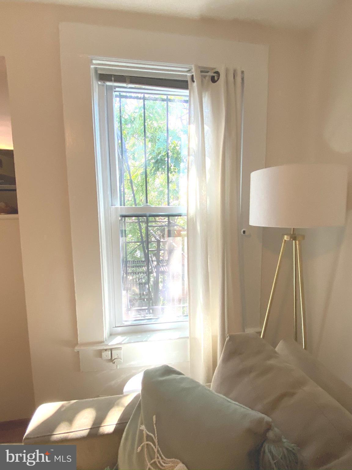 1456 Corcoran Street Northwest, Unit 3 Washington, DC 20009 - Photo 6 of 26 a living room with a bed and a window