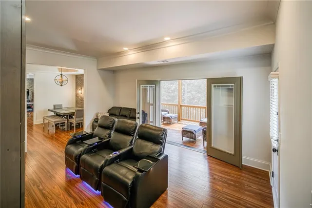 a view of a hallway with wooden floor and a bathroom
