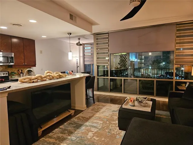 a living room with furniture a rug and kitchen view