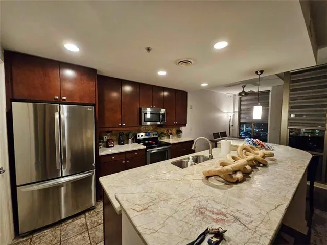 a kitchen with stainless steel appliances granite countertop a sink refrigerator and microwave