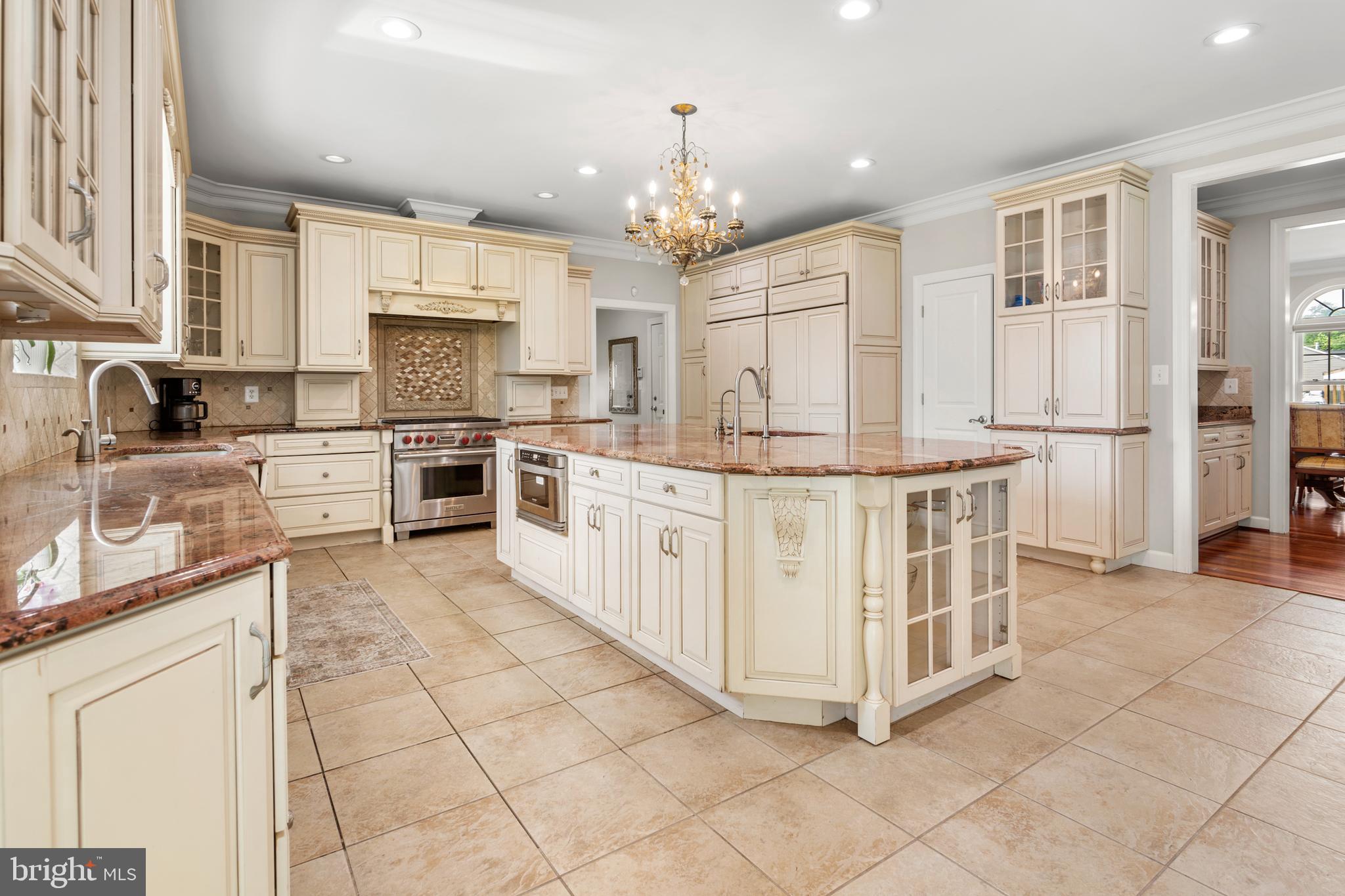 3213 Hatton Road Baltimore, MD 21208 - Photo 12 of 69 a white kitchen with stainless steel appliances granite countertop a stove top oven a sink dishwasher and white cabinets