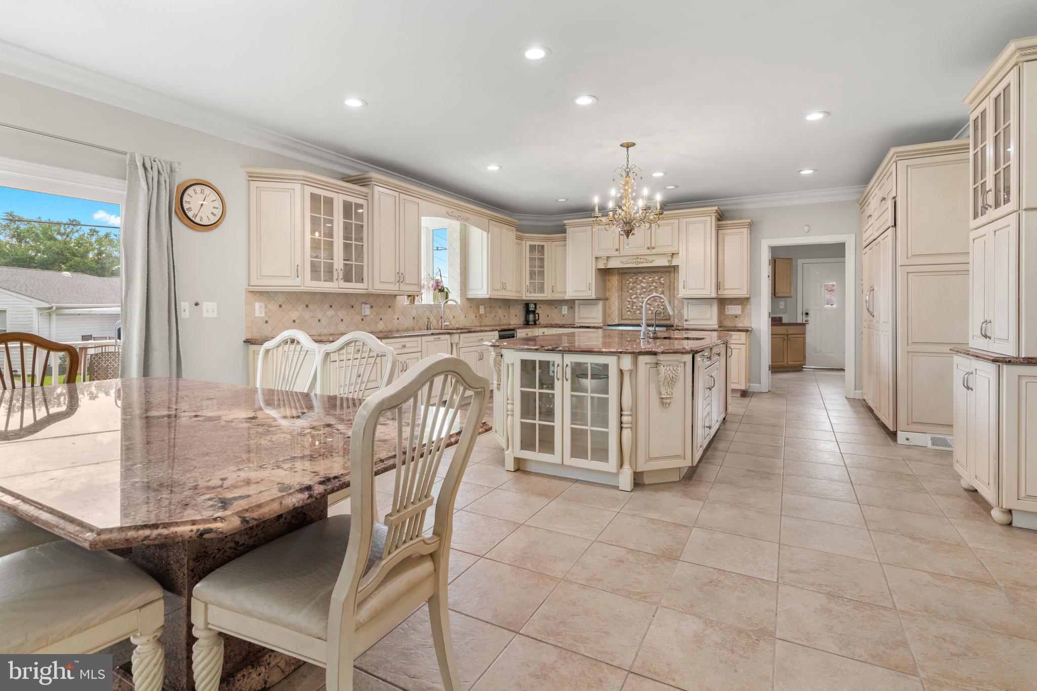 3213 Hatton Road Baltimore, MD 21208 - Photo 18 of 69 a kitchen with stainless steel appliances kitchen island granite countertop a table chairs and a refrigerator