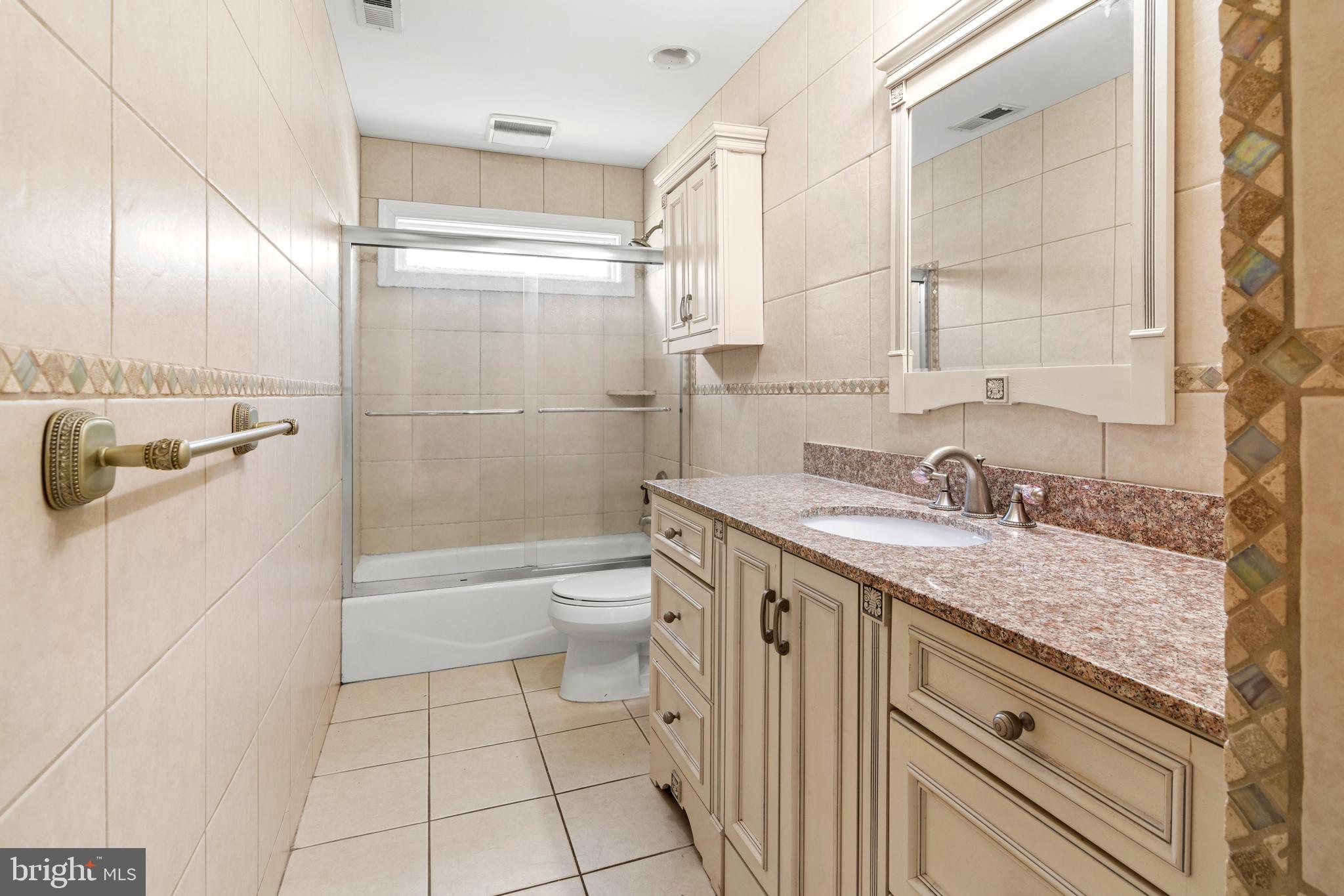 3213 Hatton Road Baltimore, MD 21208 - Photo 33 of 69 a bathroom with a granite countertop sink a toilet and shower