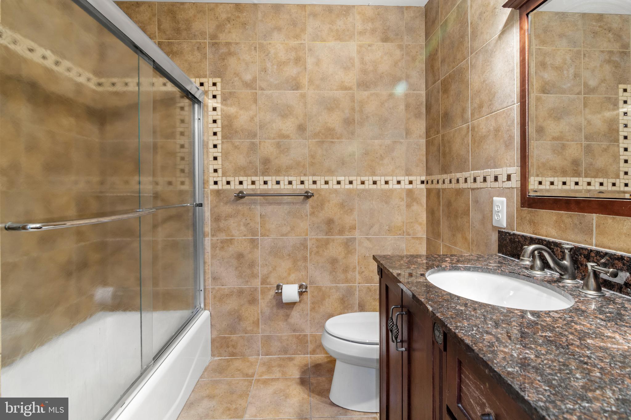 3213 Hatton Road Baltimore, MD 21208 - Photo 35 of 69 a bathroom with a granite countertop sink a toilet and shower