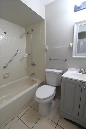 a white toilet and tub sitting next to a bathroom sink