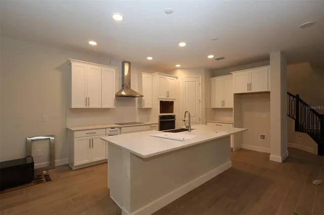 a kitchen with a sink a stove a refrigerator and white cabinets