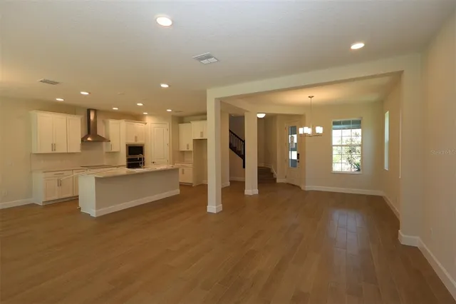 a open kitchen with white cabinets and a refrigerator