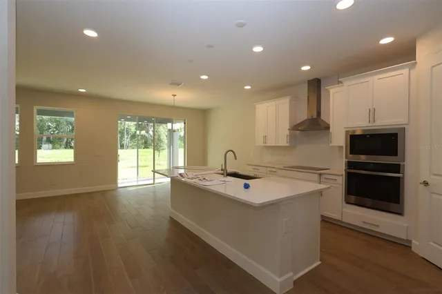 a kitchen with stainless steel appliances granite countertop a sink and a stove top oven