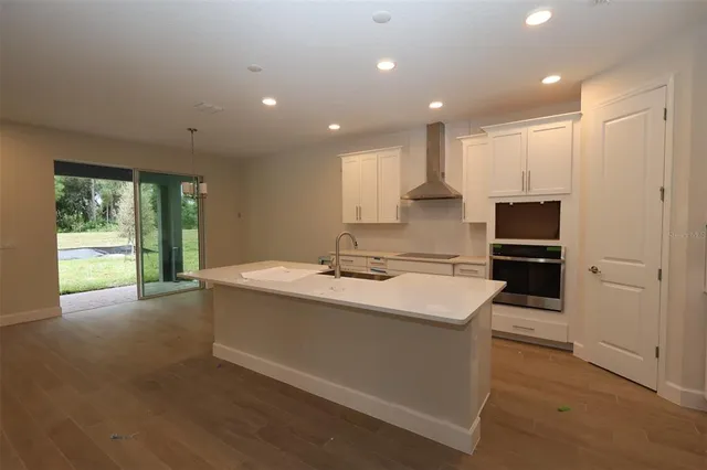 a large kitchen with kitchen island a sink stainless steel appliances and cabinets