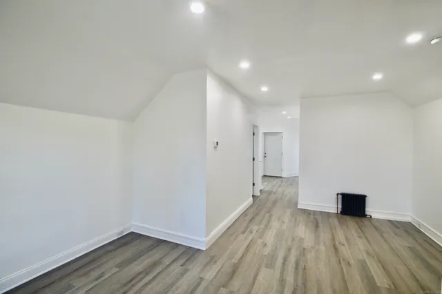 a view of a big room with wooden floor and front door