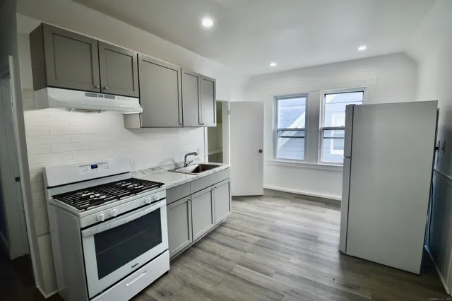 a kitchen with granite countertop a stove and a refrigerator