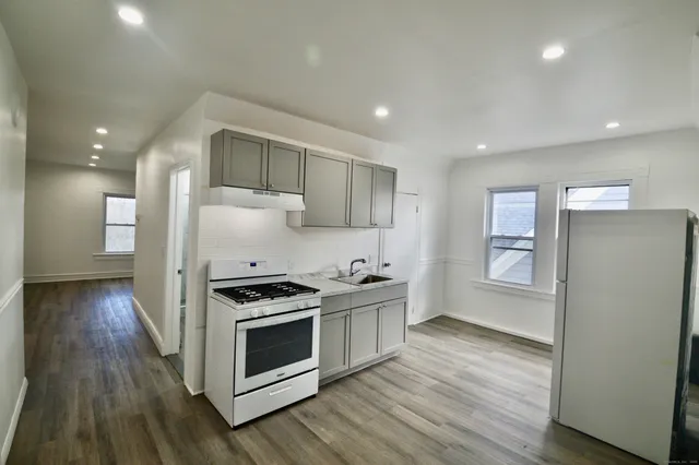 a kitchen with stainless steel appliances a stove a sink and a refrigerator