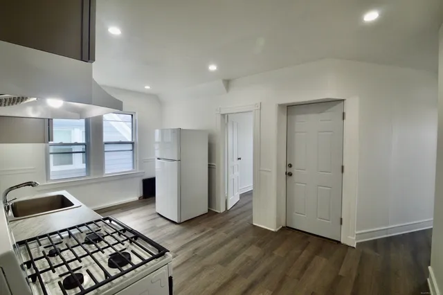 a kitchen with stainless steel appliances granite countertop a refrigerator and a stove top oven