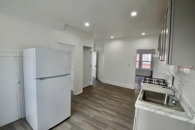 a kitchen with wooden floor and refrigerator