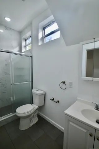 a bathroom with a sink a toilet and shower
