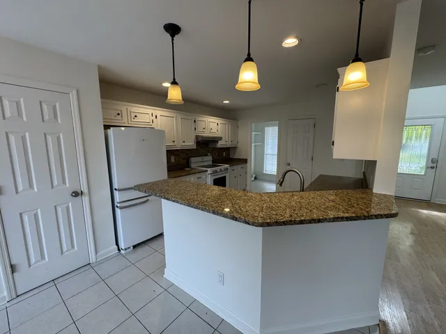 a kitchen with stainless steel appliances granite countertop a sink refrigerator and cabinets