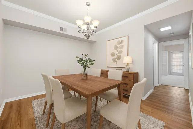 a view of a dining room with furniture a chandelier and wooden floor