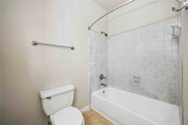 a white toilet sitting next to a bath tub and a shower
