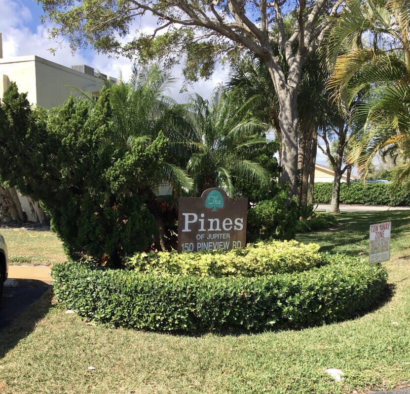150 Pineview Road, Unit L3 Jupiter, FL 33469 - Photo 2 of 12 a sign that is sitting in front of flowers