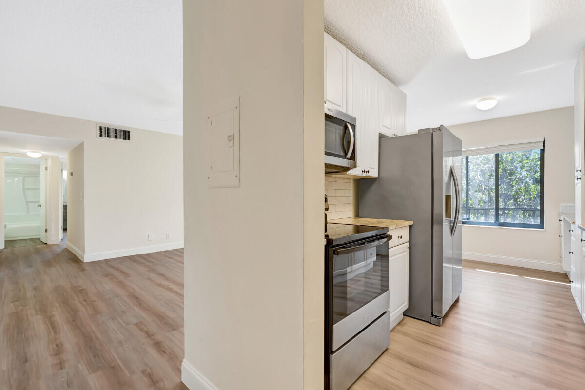 150 Pineview Road, Unit L3 Jupiter, FL 33469 - Photo 3 of 12 a kitchen with granite countertop a stove and a refrigerator