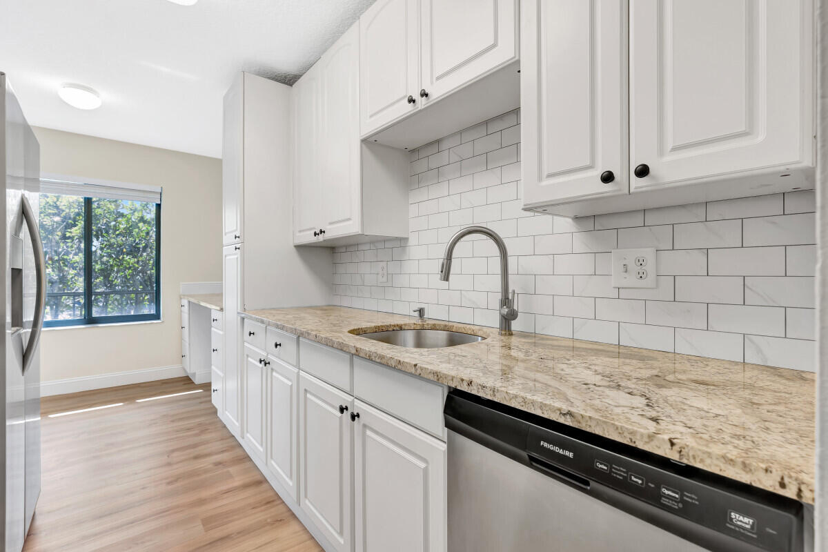 150 Pineview Road, Unit L3 Jupiter, FL 33469 - Photo 5 of 12 a kitchen with granite countertop a sink and a stove