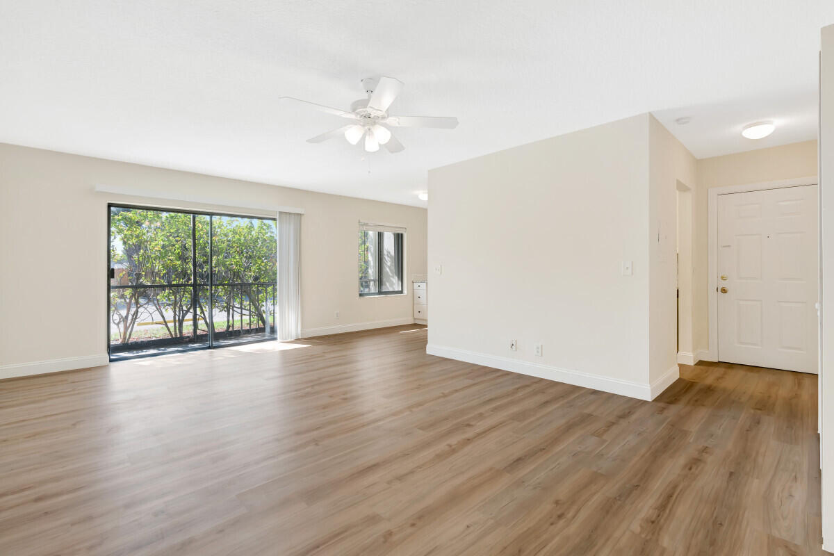150 Pineview Road, Unit L3 Jupiter, FL 33469 - Photo 7 of 12 a view of an empty room with wooden floor and a window