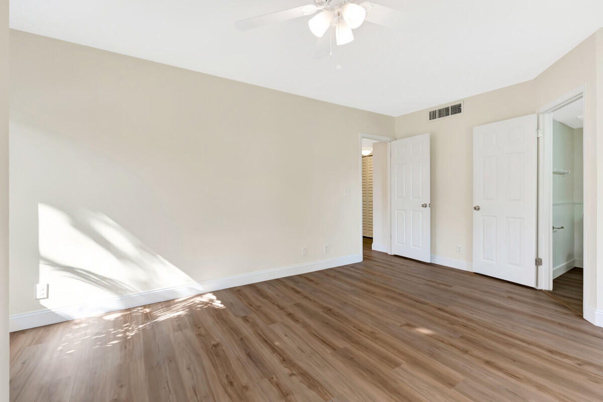 150 Pineview Road, Unit L3 Jupiter, FL 33469 - Photo 8 of 12 a view of an empty room with wooden floor