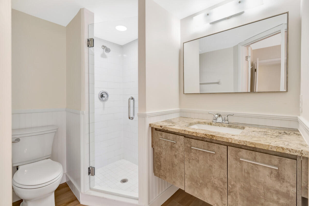 150 Pineview Road, Unit L3 Jupiter, FL 33469 - Photo 9 of 12 a bathroom with a granite countertop sink a toilet and a mirror