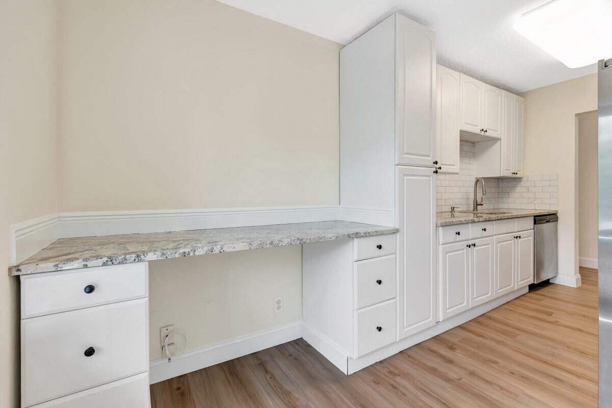 150 Pineview Road, Unit L3 Jupiter, FL 33469 - Photo 10 of 12 a kitchen with white cabinets and white appliances