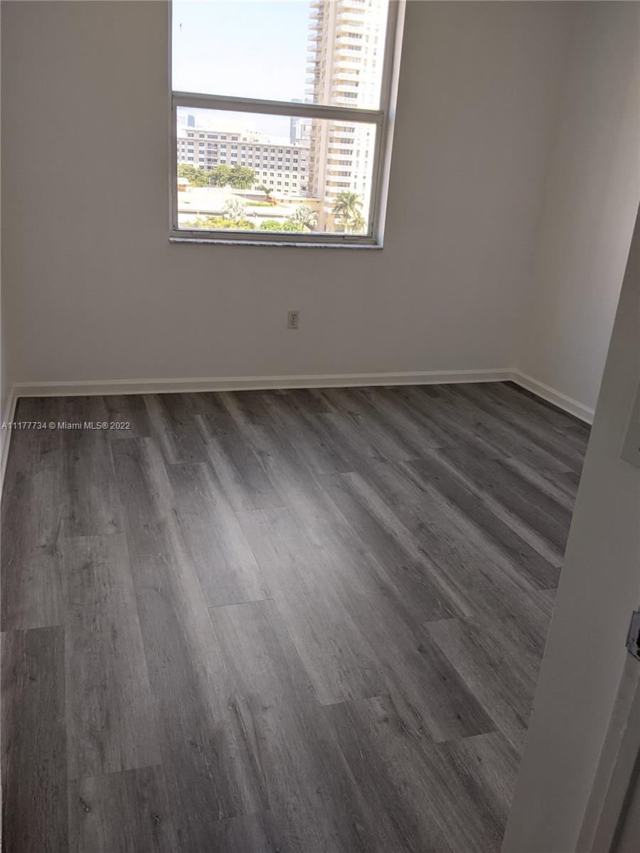 17150 North Bay Road, Unit 2814 Sunny Isles Beach, FL 33160 - Photo 22 of 25 an empty room with wooden floor and windows